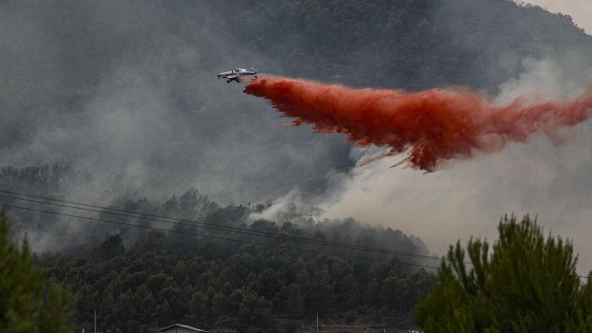 FOTODELDÍA GRAFCVA5189. BETXÍ (CASTELLÓN), 26/07/2026.- Un avión realiza una descarga con retardante en Betxí en el frente del incendio declarado este sábado en la Vall d'Uixó (Castellón), y que lleva quemadas ya unas 4.300 hectáreas y cuyo perímetro supera los 40 kilómetros. EFE/Manuel Bruque