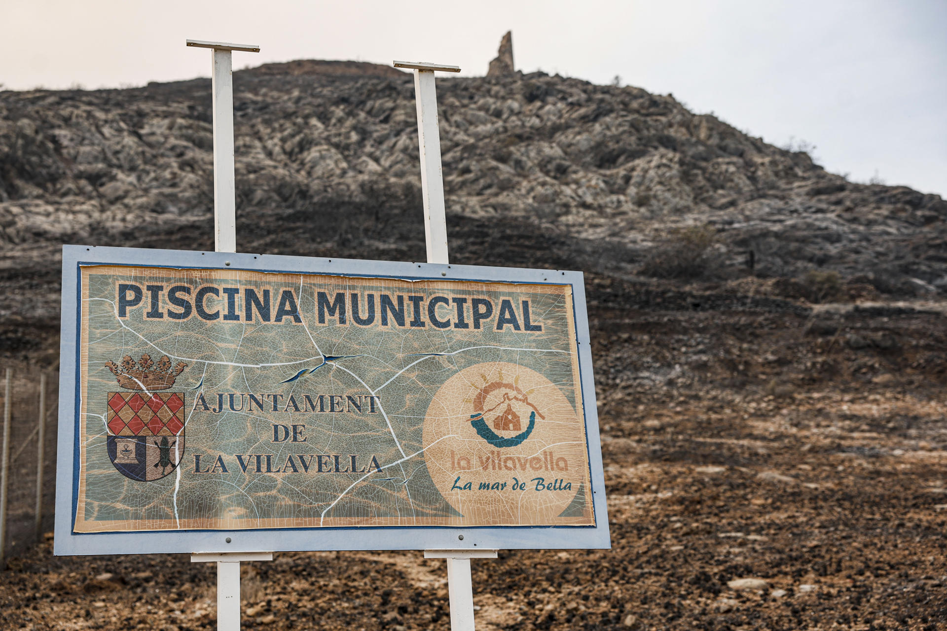 Vista del cartel de acceso a la piscina municipal del pueblo de La Vilavella (Castellón), uno de los municipios desalojados por el incendio declarado el pasado sábado en la Vall d'Uixó (Castellón). EFE/Manuel Bruque
