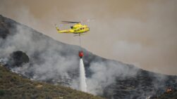 Un helicóptero del servicio de extinción de incendios arroja este viernes agua sobre uno de los focos del incendio forestal declarado en Los Gallardos.