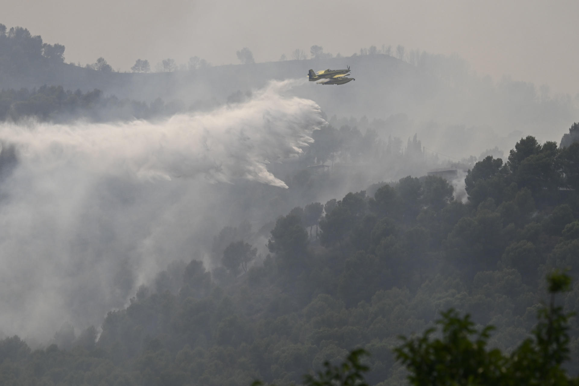 Trabajos de extinción en el incendio del Vall d'Uixó, desde el pueblo de Betxí, uno de los municipios afectados por el incendio declarado el pasado sábado en la Vall d'Uixó (Castellón), que ha arrasado ya 7.200 hectáreas y en su control trabajan más de 400 efectivos terrestres y 25 aéreos, que se centran ahora en la zona de Eslida, la urbanización Monserrat en Betxí y en el Montí en Onda. EFE/ Andreu Esteban
