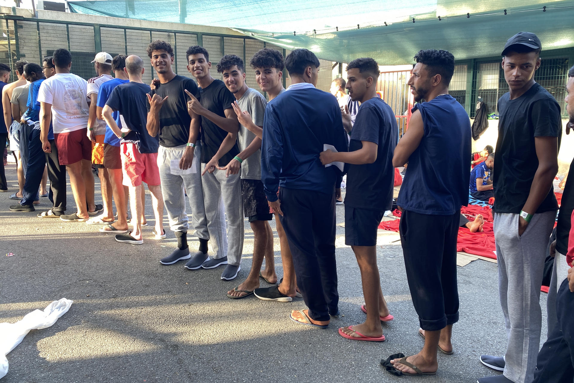 CEUTA, 26/07/2026.- Decenas de migrantes, principalmente marroquíes y argelinos, en un número superior a las 120 personas, colapsan las puertas de acceso al Centro de Estancia Temporal de Inmigrantes (CETI) de Ceuta como consecuencia de un incremento en las entradas ilegales por la vía marítima. EFE/Rafael Peña
