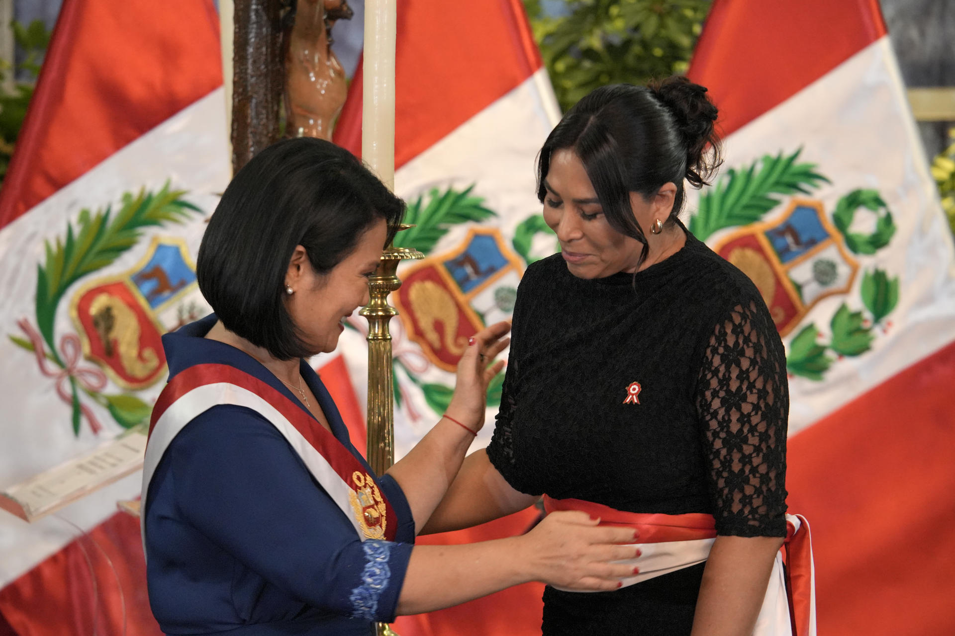 La presidenta de Perú, Keiko Fujimori, reacciona junto a la ministra de Desarrollo e Inclusión Social, Maritza Canales, durante la toma de juramento de su gabinete ministerial en Lima 