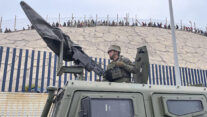 CEUTA (ESPAÑA), 31/07/2026.- El ejército desplegando en la frontera del Tarajal en Ceuta ante la atenta mirada de los inmigrantes este viernes, donde se han registrado violentos enfrentamientos en los perímetros fronterizos durante su intento de acceder desde Marruecos hacia Ceuta y Melilla. EFE/ Reduan Dris