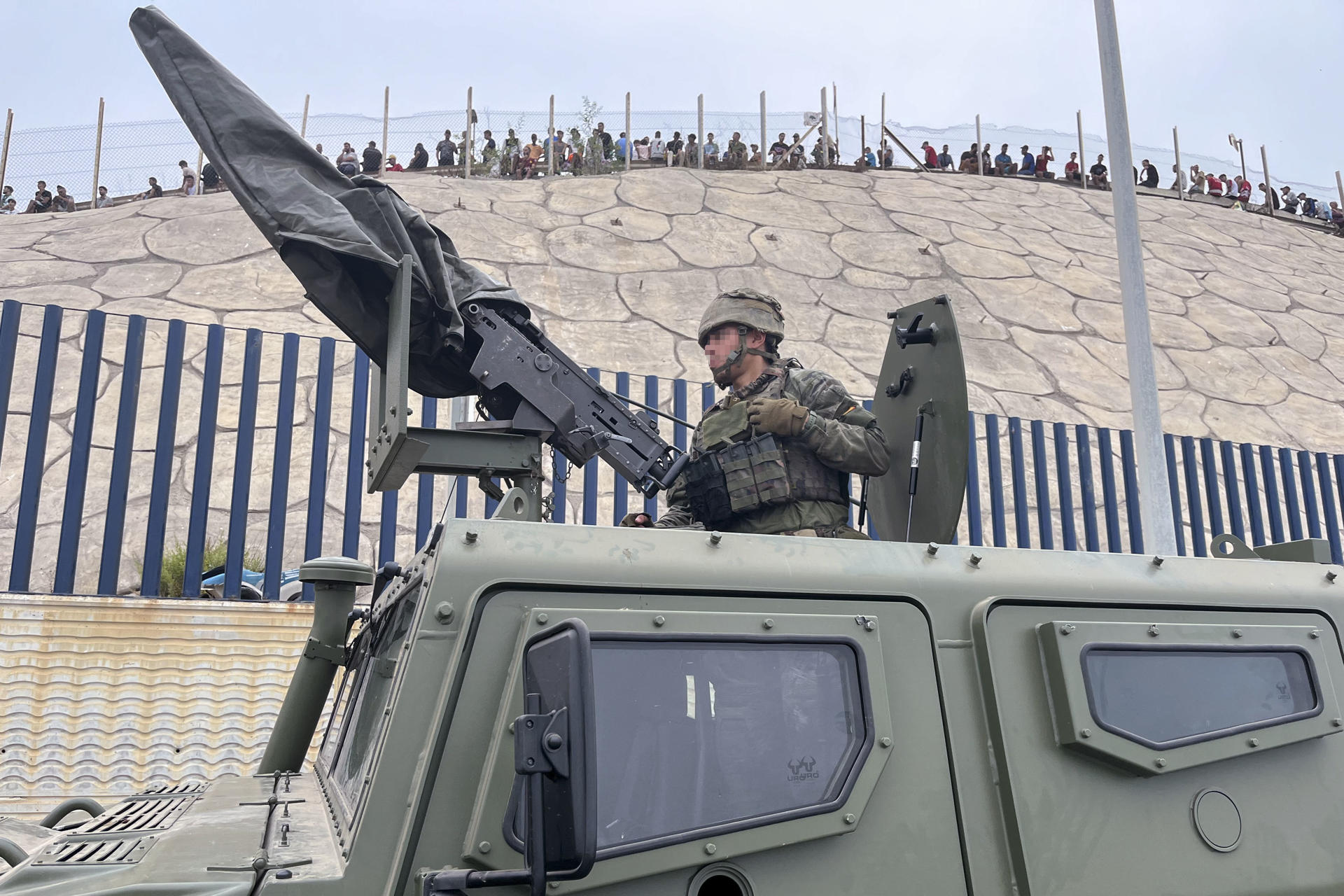 CEUTA (ESPAÑA), 31/07/2026.- El ejército desplegando en la frontera del Tarajal en Ceuta ante la atenta mirada de los inmigrantes este viernes, donde se han registrado violentos enfrentamientos en los perímetros fronterizos durante su intento de acceder desde Marruecos hacia Ceuta y Melilla. EFE/ Reduan Dris