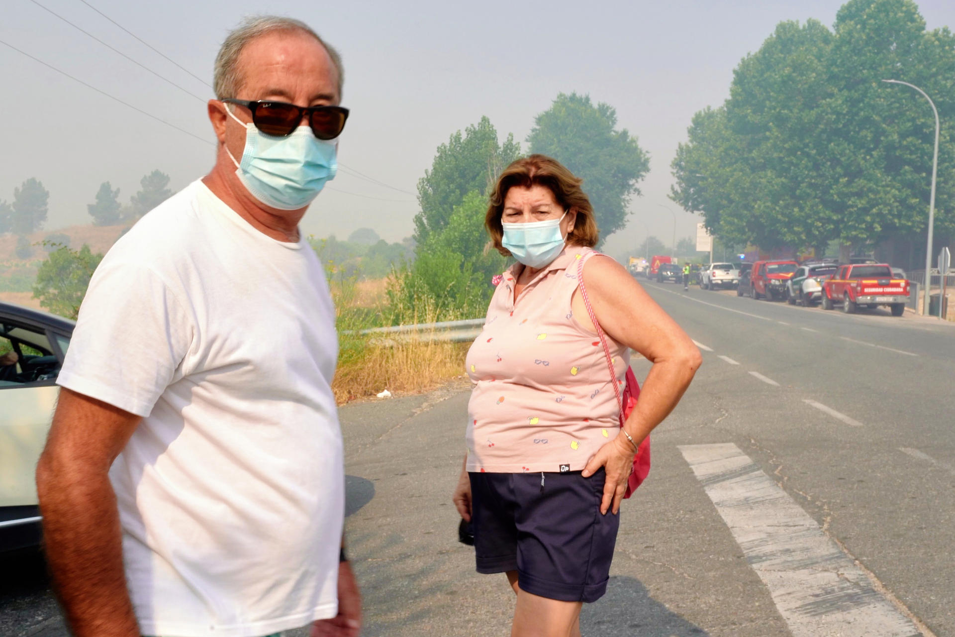 Vecinos de Navaluenga utilizan mascarillas para protegerse del humo del incendio de Burgohondo (Ávila). EFE/ Raúl Sanchidrián