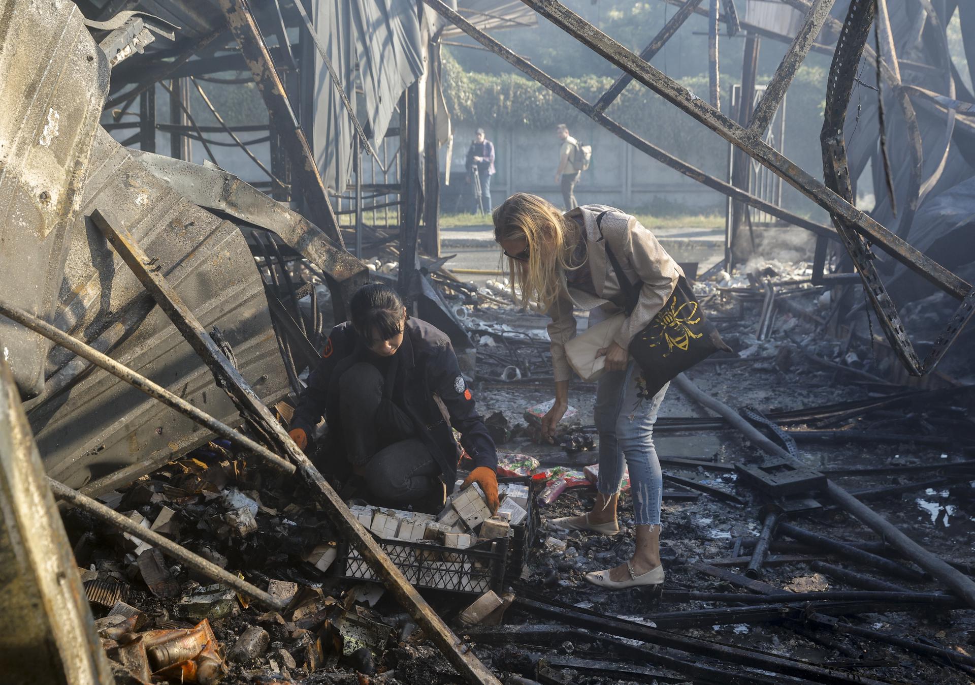 KYIV (Ukraine), 30/07/2026.- Ukrainian sellers try to save belongings at the site of a Russian missile strike on a market in Kyiv, Ukraine, 30 July 2026, amid the Russian invasion. At least eight people died, and dozens of people were injured after an overnight massive combined Russian attack in Ukraine, according to the State Emergency Service. Russia launched at least 70 missiles of different types and more than 280 shock drones during the overnight massive attacks across the country, the air forces reported. (Rusia, Ucrania, Kiev) EFE/EPA/SERGEY DOLZHENKO