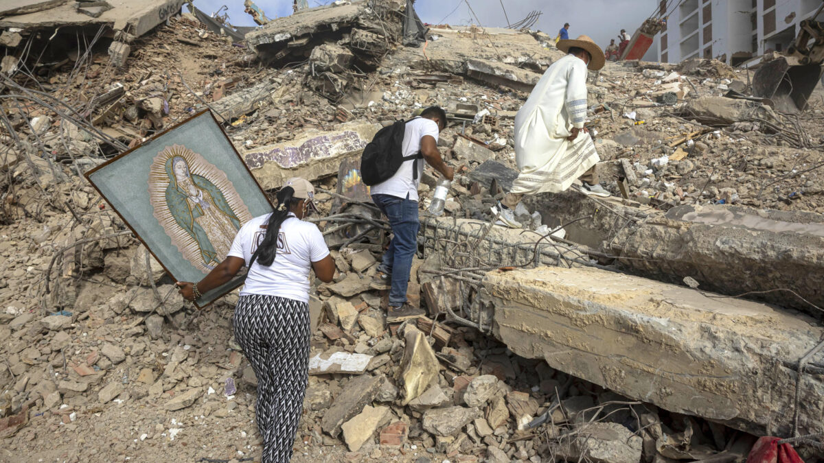 sacerdote Omar Pérez Gabino (d) caminando durante un recorrido para acompañar con oraciones a familiares, voluntarios y rescatistas que continúan las labores de recuperación de cuerpos atrapados bajo los escombros tras los terremotos del pasado 24 de junio en Venezuela. EFE/ Miguel Gutiérrez