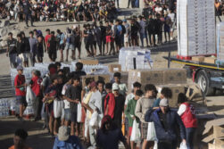 FOTODELDÍA - CEUTA, 27/08/2026.- Inicio del reparto de alimentos por parte de miembros de Cruz Roja a los migrantes en la playa del Trampolín, este jueves en Ceuta. EFE/Reduan