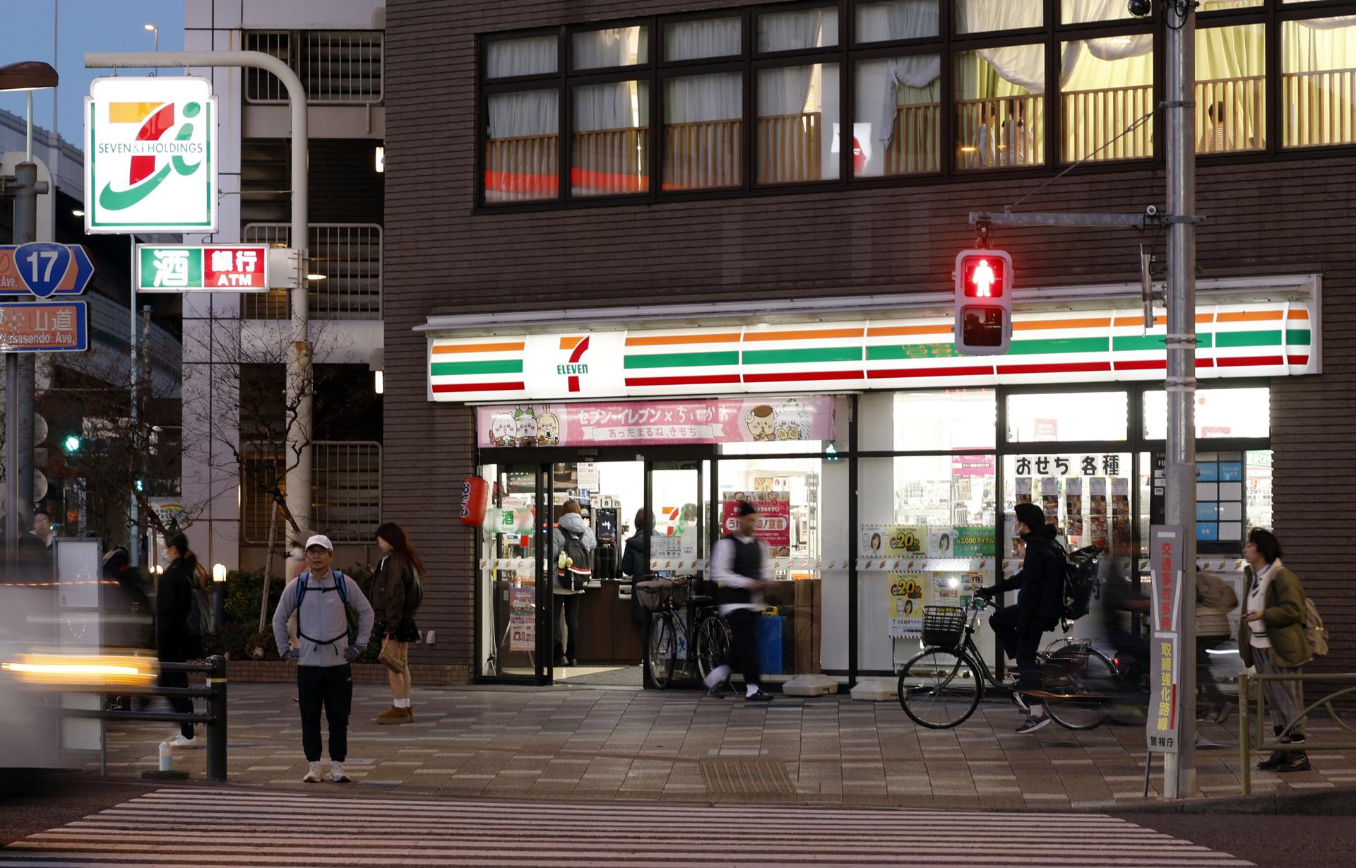 Tokyo (Japan), 13/12/2024.- People walk past a 7-Eleven convenience store in Tokyo, Japan, 12 December 2024 (issued 13 December 2024). The convenience stores of American origin that Japan transformed into a cultural empire within half a century are known as 'konbini', with the first one opening its doors fifty years ago in Tokyo. 7-Eleven entered the country as a US business but transitioned to Japanese ownership in 2005. (Japón, Tokio) EFE/EPA/FRANCK ROBICHON ATTENTION: This Image is part of a PHOTO SET