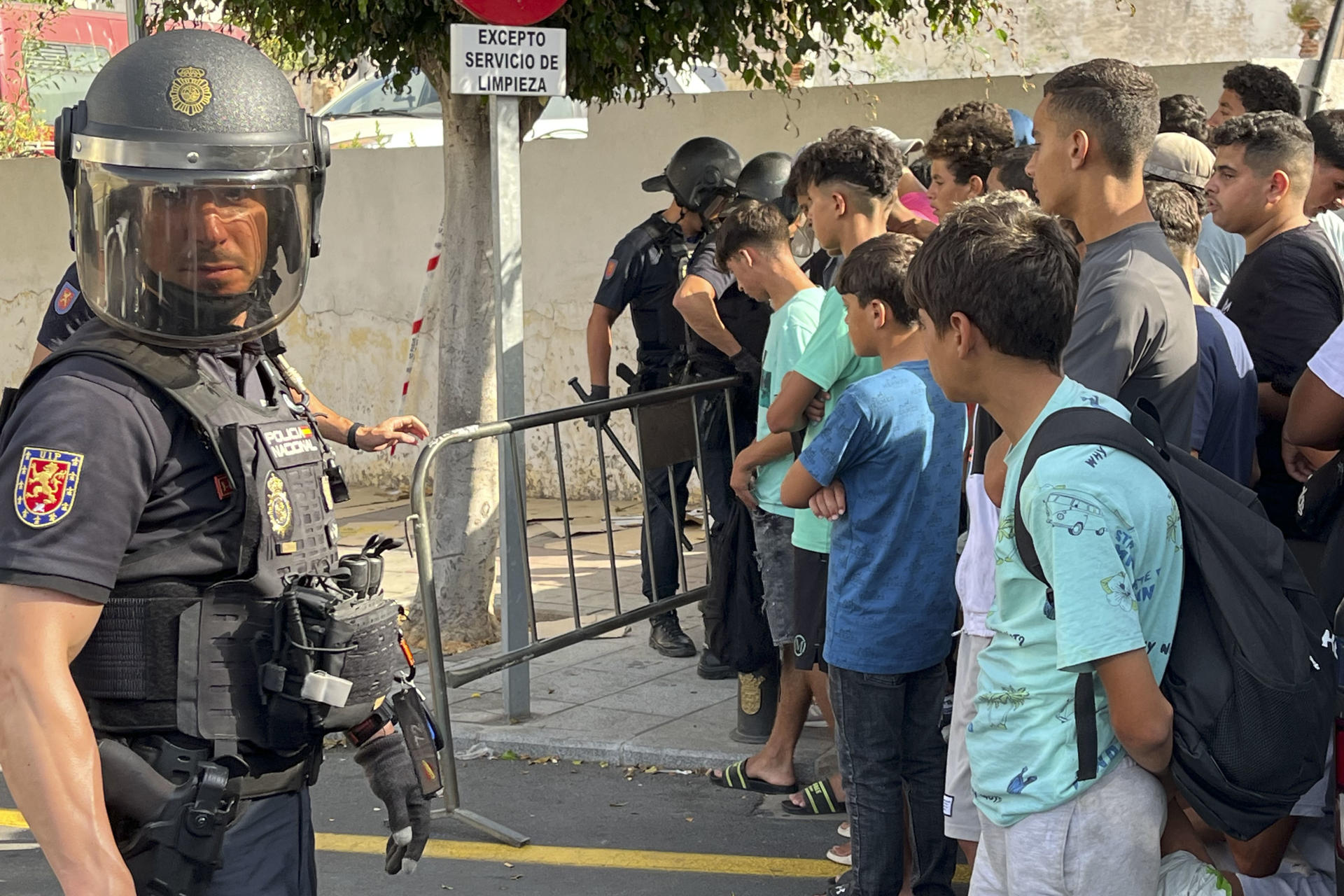 CEUTA, 10/08/2026.-Multitud de menores migrantes esperan para su filiación frente a la Jefatura Superior de la Policía Nacional en Ceuta este lunes. La situación en Ceuta sigue lejos de normalizarse, con campamentos provisionales para muchos migrantes y miles de menores a la espera de una solución, y continúa marcando la disputa entre el Gobierno y el PP, que mantiene el pulso para que tres ministros comparezcan en el Senado aunque desde el Ejecutivo solo piensen hacerlo en el Congreso. -EFE/ Reduan