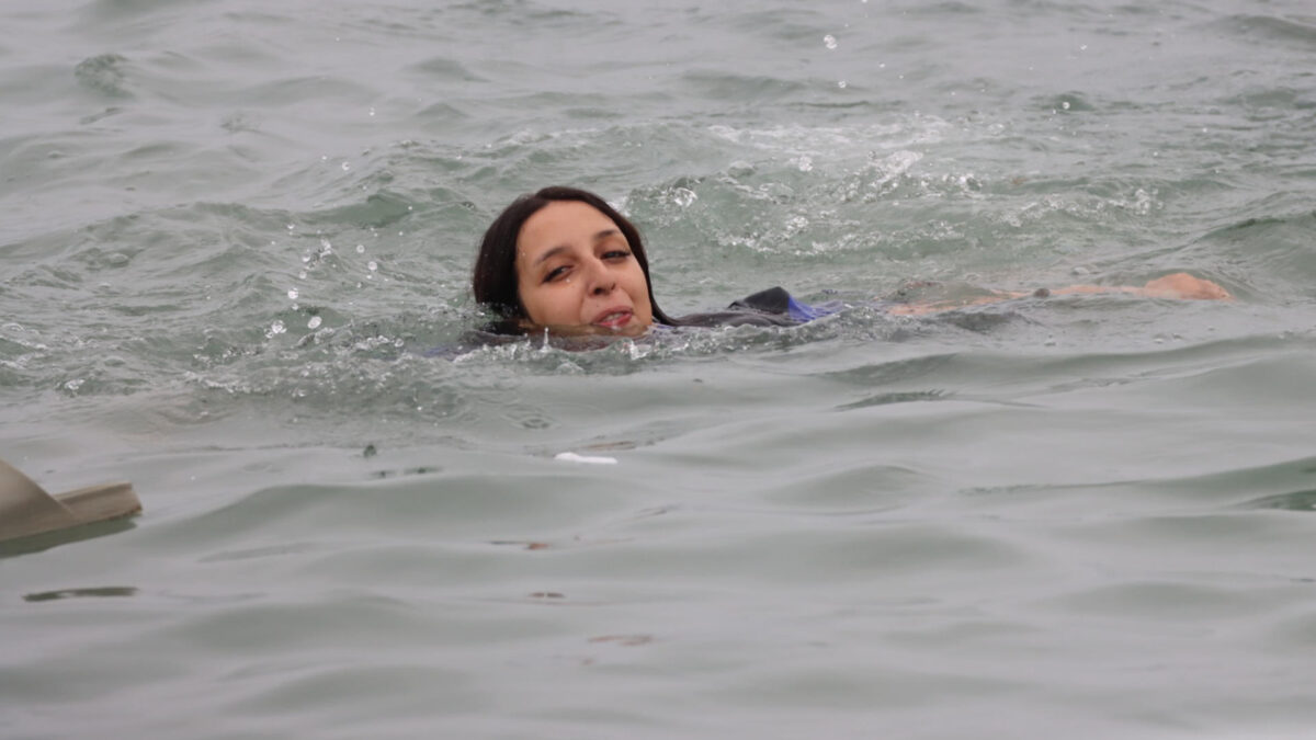 CEUTA (ESPAÑA), 31/07/2026.- Una inmigrante en la playa junto al paso fronterizo del Tarajal en Ceuta este viernes, donde se han registrado violentos enfrentamientos en los perímetros fronterizos durante su intento de acceder desde Marruecos hacia Ceuta y Melilla. EFE/ Reduan Dris