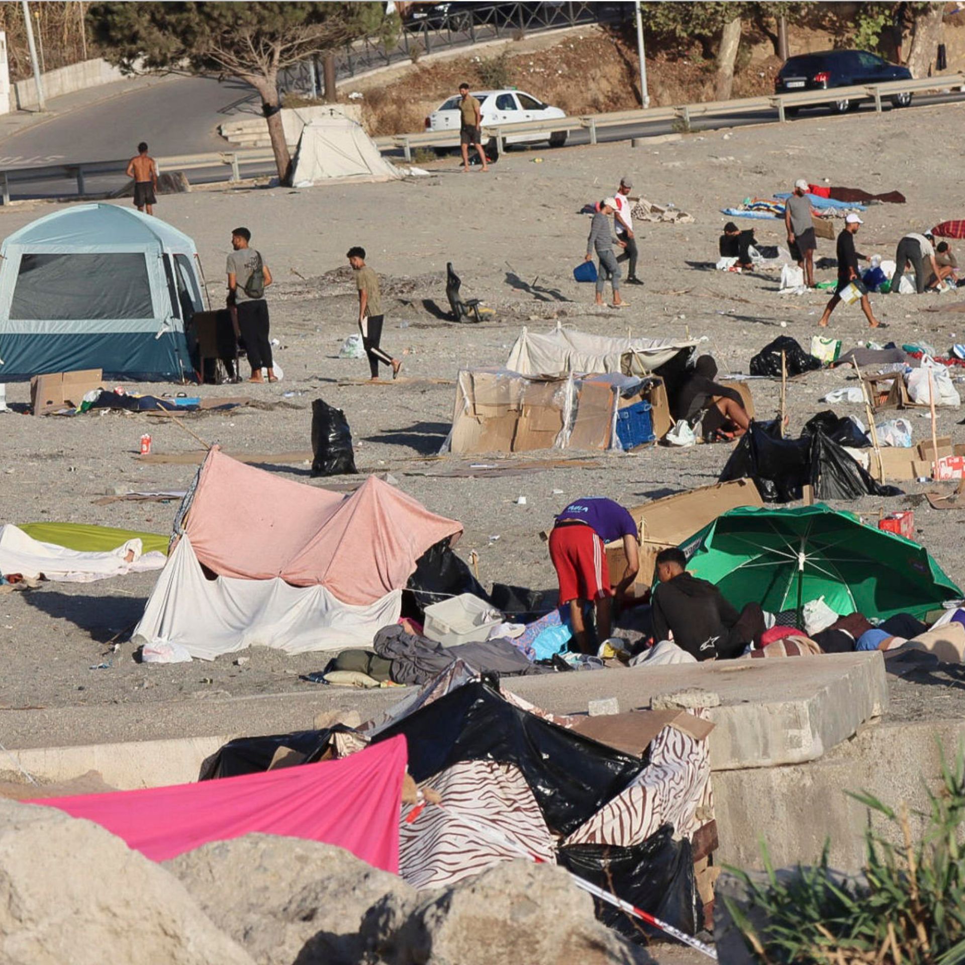 Varios migrantes permanecen este lunes acampados en la playa de El Trampolín de Ceuta.