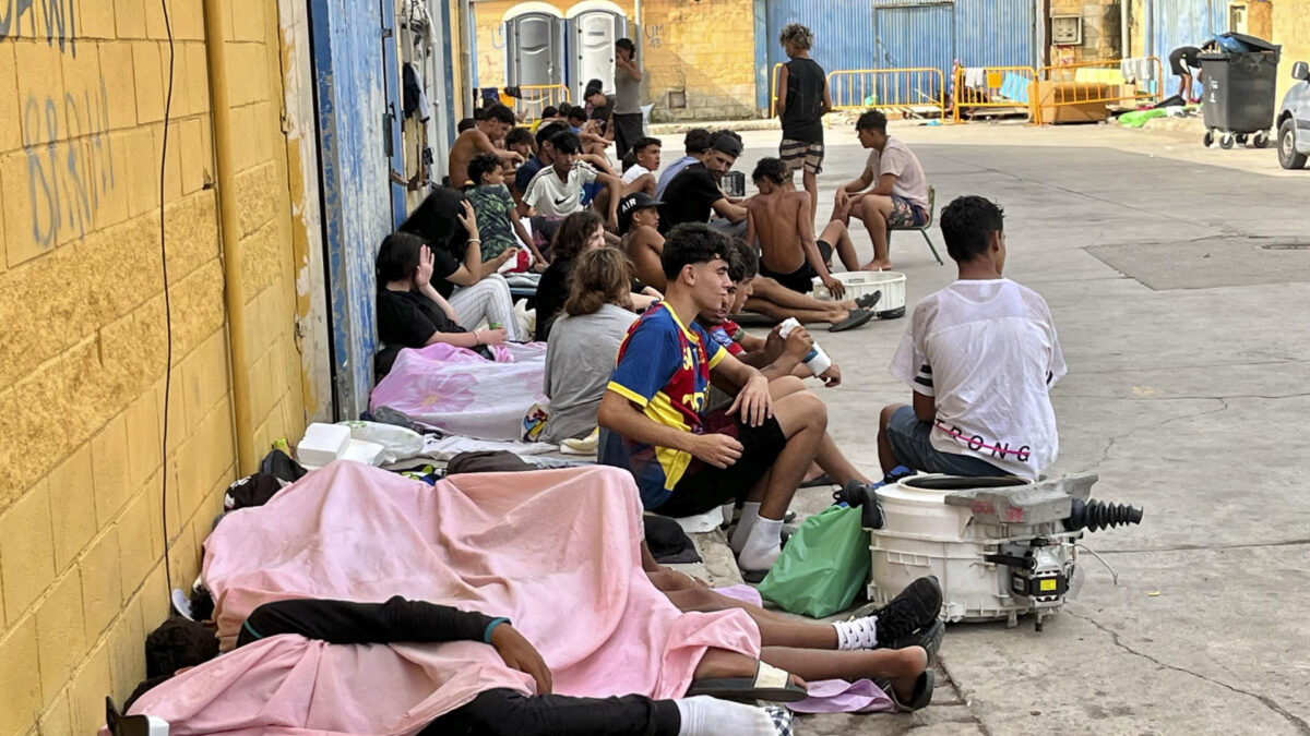 CEUTA, 03/08/2026.- Cientos de inmigrantes marroquíes descansan en las calles de Ceuta, este lunes. La vigilancia en el entorno de la frontera del Tarajal, tanto por vía marítima como terrestre, así como los nuevos medios de contención en la zona con la instalación de una barrera en el mar han reducido al mínimo las entradas a nado desde Marruecos. EFE/Reduan