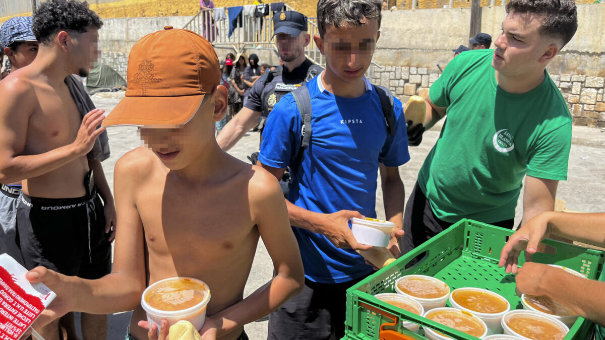 CEUTA (ESPAÑA), 07/08/2026.- Vista de un momento del reparto de comida que lleva a cabo el ONG Luna Blanca a las personas migrantes este viernes, en la zona de las naves del Tarajal (Ceuta). EFE/ Reduan