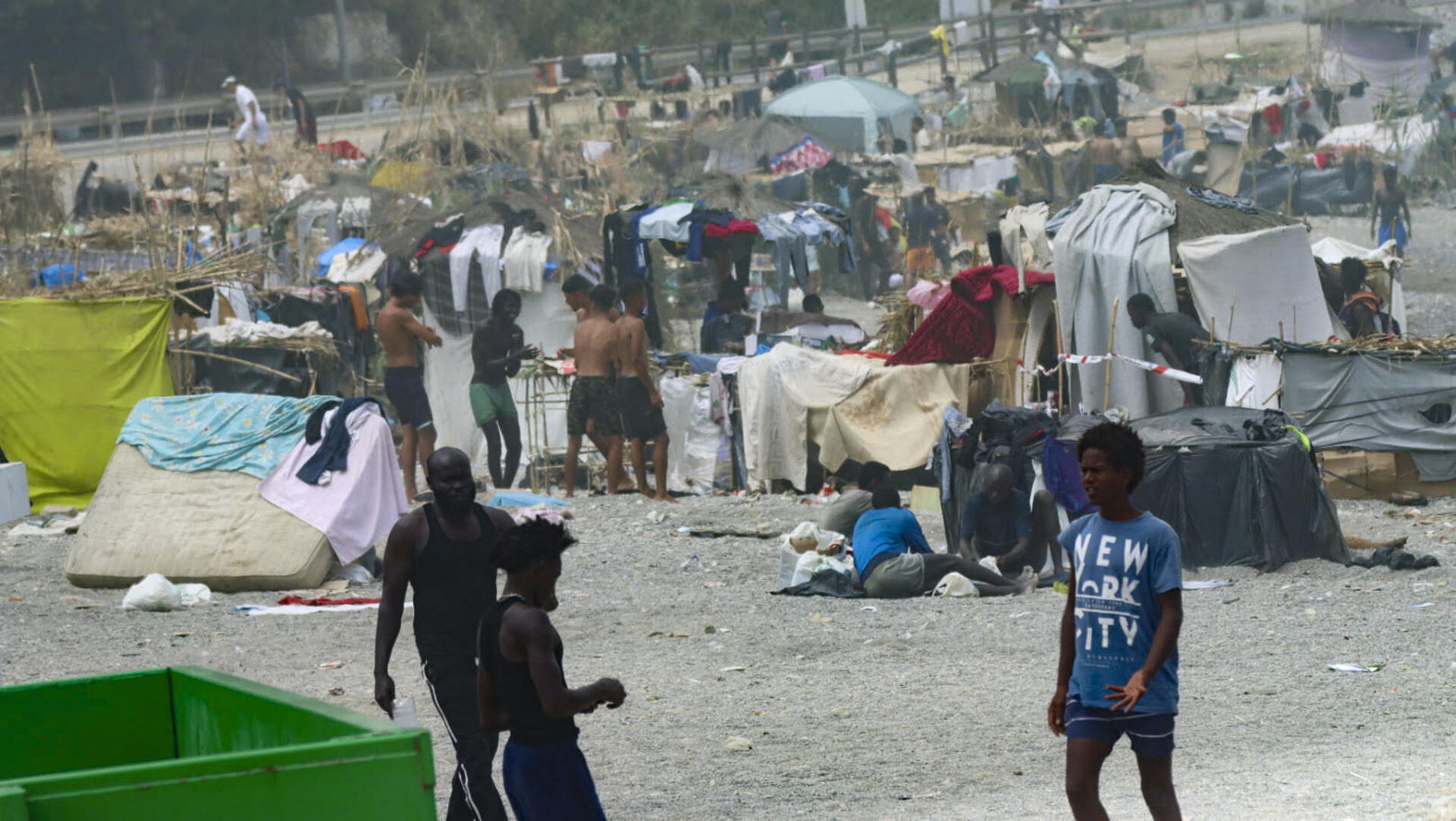 CEUTA, 14/08/2026.- Vista de la playa El Trampolín de Ceuta donde se encuentran los migrantes que llegaron a la playa del Tarajal. La entrada masiva de migrantes desde Marruecos a Ceuta, el 30 de julio, ha provocado una tragedia sin precedentes en esta frontera, con más de 70.000 personas que cruzaron a pie o nado al enclave español; 141 muertos, según organizaciones humanitarias, y tensiones entre Madrid y Rabat. EFE/ Reduan