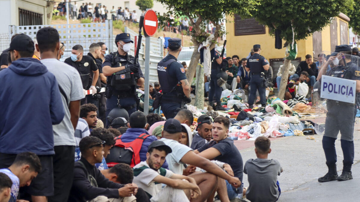 CEUTA, 31/08/2026.- Migrantes frente a la explanada de embotellamiento de Loma Colmenar donde hace casi dos semanas, se habilitó un campamento temporal para realojar a los migrantes pero de momento no es posible ya que no hay suficientes espacio para montar más carpas militares en la mencionada explanada. El Gobierno local de Ceuta y otros colectivos y organizaciones siguen reclamando la expulsión de los miles de migrantes que permanecen todavía en el territorio un mes después de la entrada de más de 70.000 personas a través de la frontera con Marruecos. EFE/Reduan