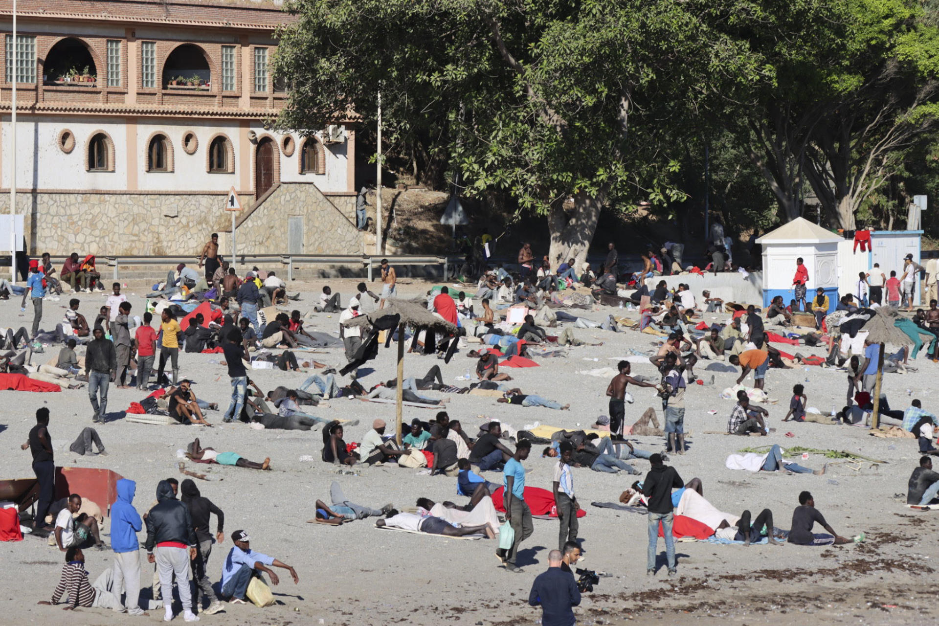 *CORRIGE FECHA* CEUTA, 04/08/2026.- Migrantes en la playa El trampolín en Ceuta este martes. La frontera del Tarajal que separa Ceuta de Marruecos ha amanecido este martes con tranquilidad ya que no se han registrado nuevos intentos de entrada por el espigón fronterizo, si bien el retorno de personas de forma voluntaria a Marruecos ya se está produciendo con cuentagotas. EFE/Reduán