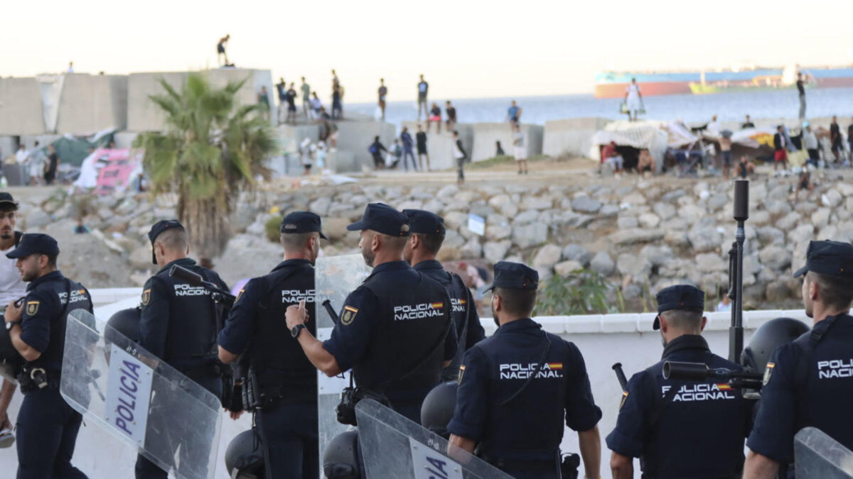 CEUTA, 28/08/2026.- La Policía Nacional controla las inmediaciones de la playa del Trampolín para evitar posibles incidentes entre los migrantes y los manifestantes que protestan ante la crisis de inmigración, este viernes en Ceuta. EFE/Reduan