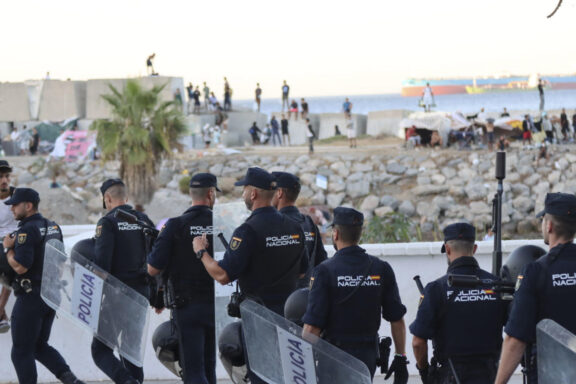 CEUTA, 28/08/2026.- La Policía Nacional controla las inmediaciones de la playa del Trampolín para evitar posibles incidentes entre los migrantes y los manifestantes que protestan ante la crisis de inmigración, este viernes en Ceuta. EFE/Reduan
