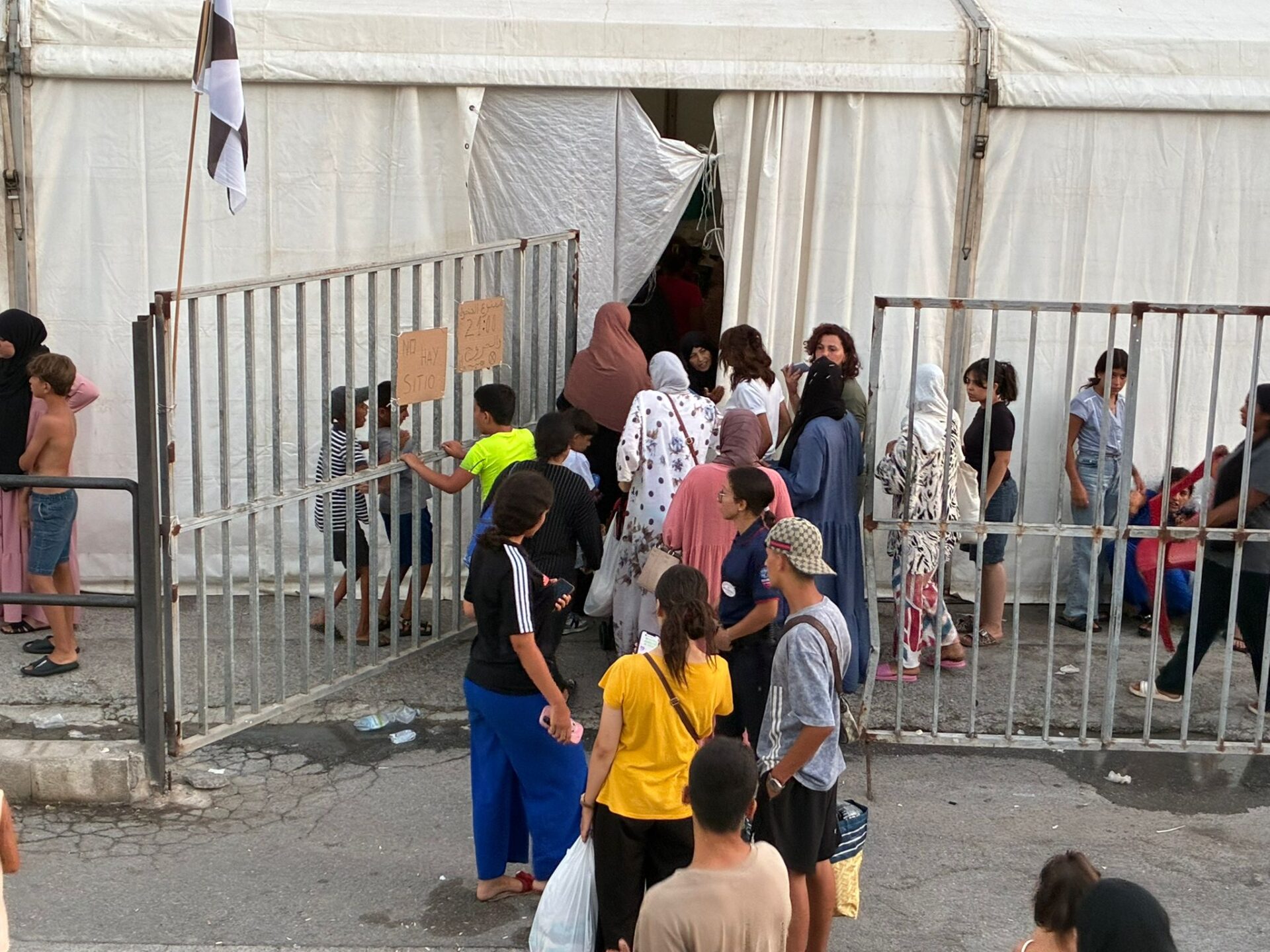 Una fila de mujeres espera para entrar en las carpas de Sidi Embarek, donde se lee el cartel de "No hay sitio". María Serrano