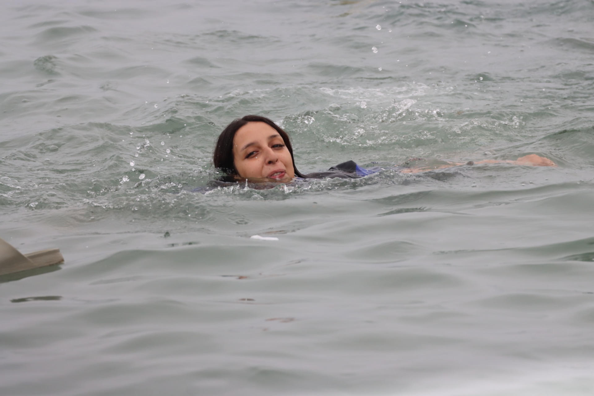 CEUTA (ESPAÑA), 31/07/2026.- Una inmigrante en la playa junto al paso fronterizo del Tarajal en Ceuta este viernes, donde se han registrado violentos enfrentamientos en los perímetros fronterizos durante su intento de acceder desde Marruecos hacia Ceuta y Melilla. EFE/ Reduan Dris