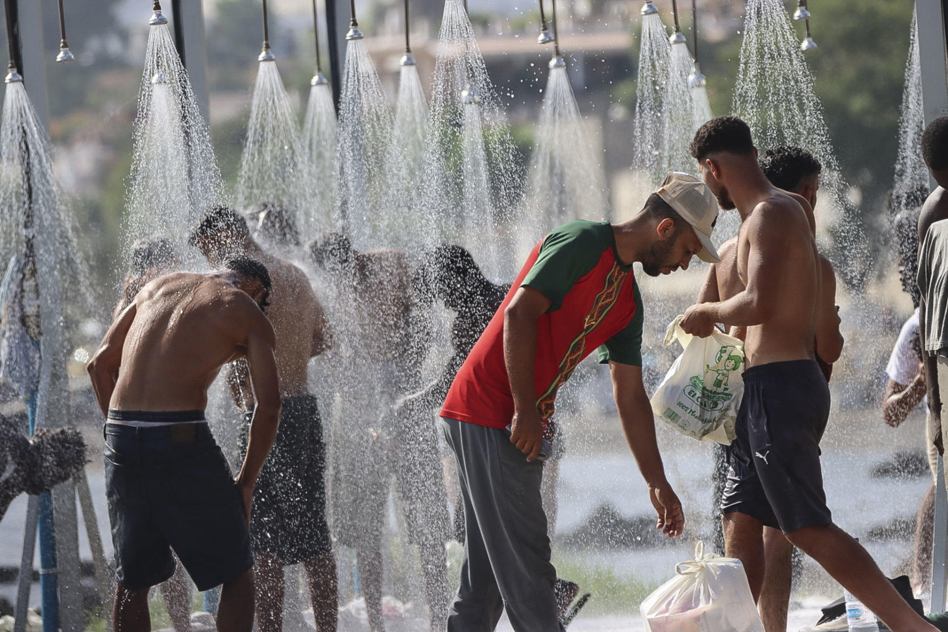 CEUTA, 19/08/2026.- Miles de migrantes siguen viviendo en la playa del Trampolín y en otros lugares de Ceuta al aire libre mientras continúan los trabajos para instalar y acondicionar las carpas que en principio van a acoger a 1.500 personas. EFE/Reduan