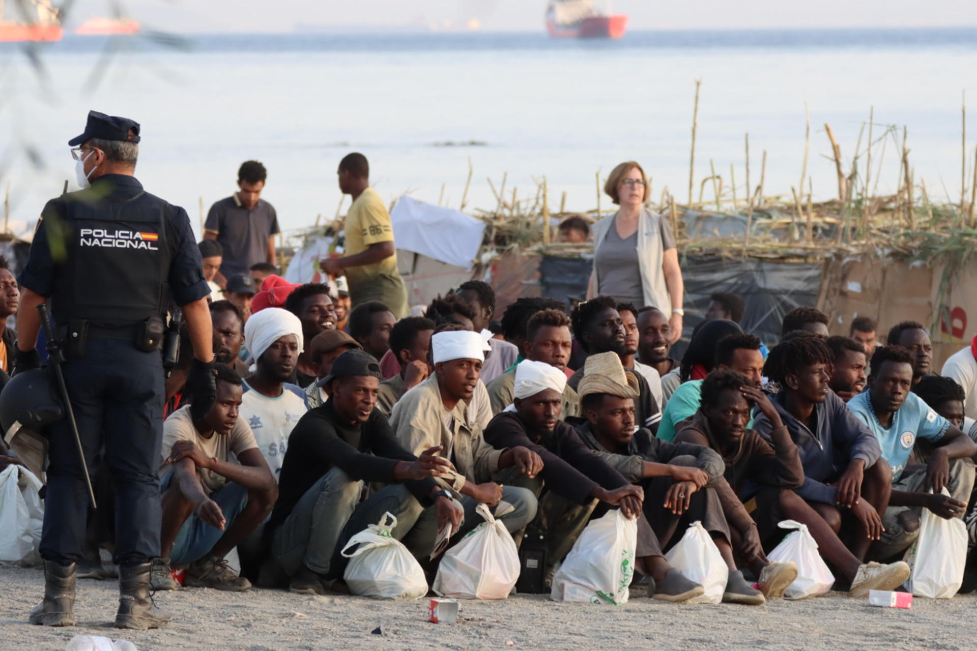 CEUTA, 20/08/2026.- Migrantes son desalojados de la playa del Trampolín en Ceuta tras habilitarse un espacio para su acogida este jueves. El Gobierno ha habilitado temporalmente varios espacios para la acogida de 1.800 personas migrantes que se encuentran en situación de calle en la playa del Trampolín y en la zona de Loma Colmenar, en Ceuta, que prevé ampliar progresivamente. EFE/Reduan