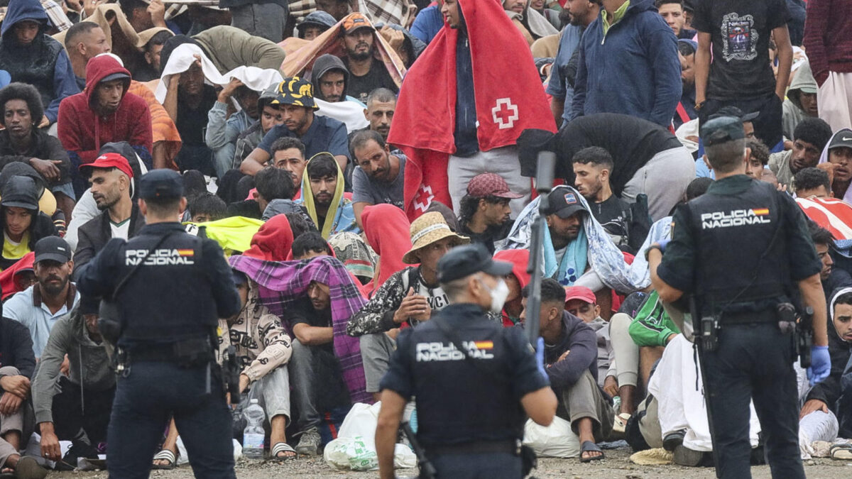 CEUTA, 21/08/2026.- La policía vigila a inmigrantes que continúan viviendo en las inmediaciones de la playa del Trampolín en Ceuta, este viernes. El secretario de Estado Juventud e Infancia, Rubén Pérez Correa, ha considerado "factible" llevar a cabo "en un plazo de pocas semanas" el traslado de 500 niñas migrantes no acompañadas desde Ceuta a la Península y, para ello, confía en la "voluntad" del Gobierno de la ciudad autónoma. EFE/Reduan