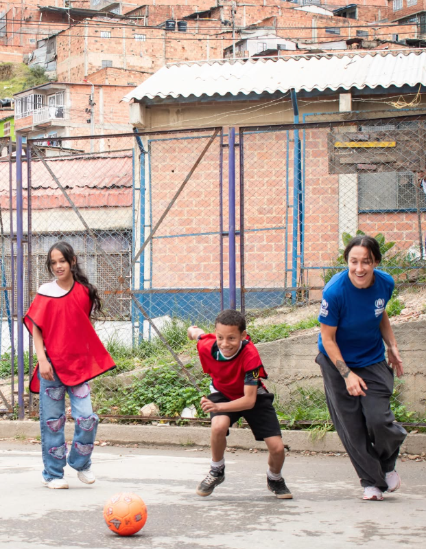La futbolista Lucy Bronze jugando al fútbol con algunos de los niños que visitó en Colombia durante sus vacaciones