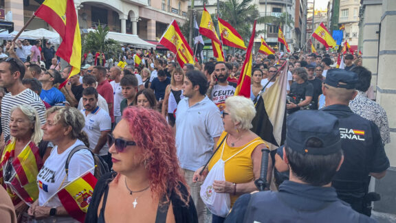 CEUTA, 26/08/2026.- Concentración este miércoles frente a la sede de la Delegación del Gobierno en Ceuta en protesta por la crisis migratoria que afecta a la ciudad. El Gobierno sacará los polideportivos de Ceuta del listado de instalaciones susceptibles de alojar a los miles de migrantes que permanecen en la ciudad tras la entrada masiva de personas desde Marruecos de finales de julio. EFE/Reduan