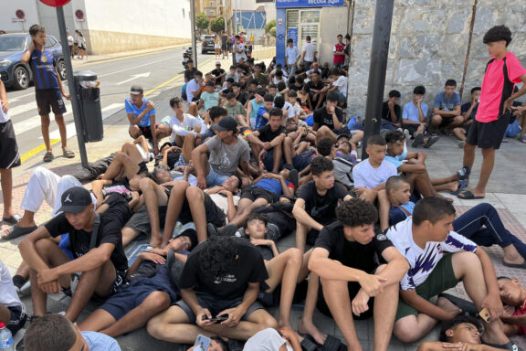Multitud de menores migrantes esperan para su filiación frente a la Jefatura Superior de la Policía Nacional en Ceuta.