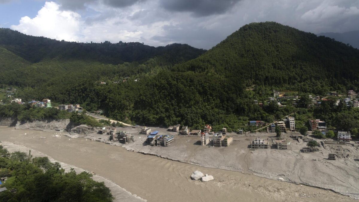 People watch as floodwaters sweep through Trishuli Bazar following a flash flood, in Nuwakot district, Nepal, 26 August 2026. Several people were killed and multiple others were reported missing after a massive flash flood swept through Rasuwa and Nuwakot districts causing widespread destruction to settlements and infrastructure, according to local authorities. (Inundaciones)