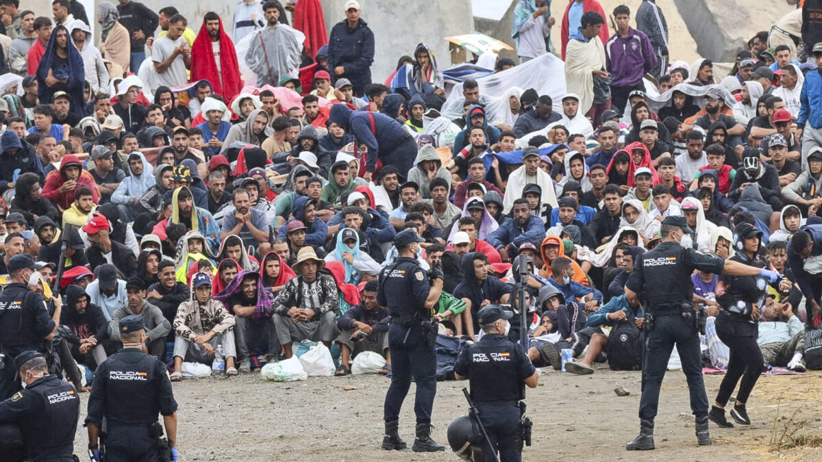 FOTODELDIA CEUTA, 21/08/2026.- La policía vigila a inmigrantes que continúan viviendo en las inmediaciones de la playa del Trampolín en Ceuta, este viernes. El secretario de Estado Juventud e Infancia, Rubén Pérez Correa, ha considerado "factible" llevar a cabo "en un plazo de pocas semanas" el traslado de 500 niñas migrantes no acompañadas desde Ceuta a la Península y, para ello, confía en la "voluntad" del Gobierno de la ciudad autónoma. EFE/Reduan