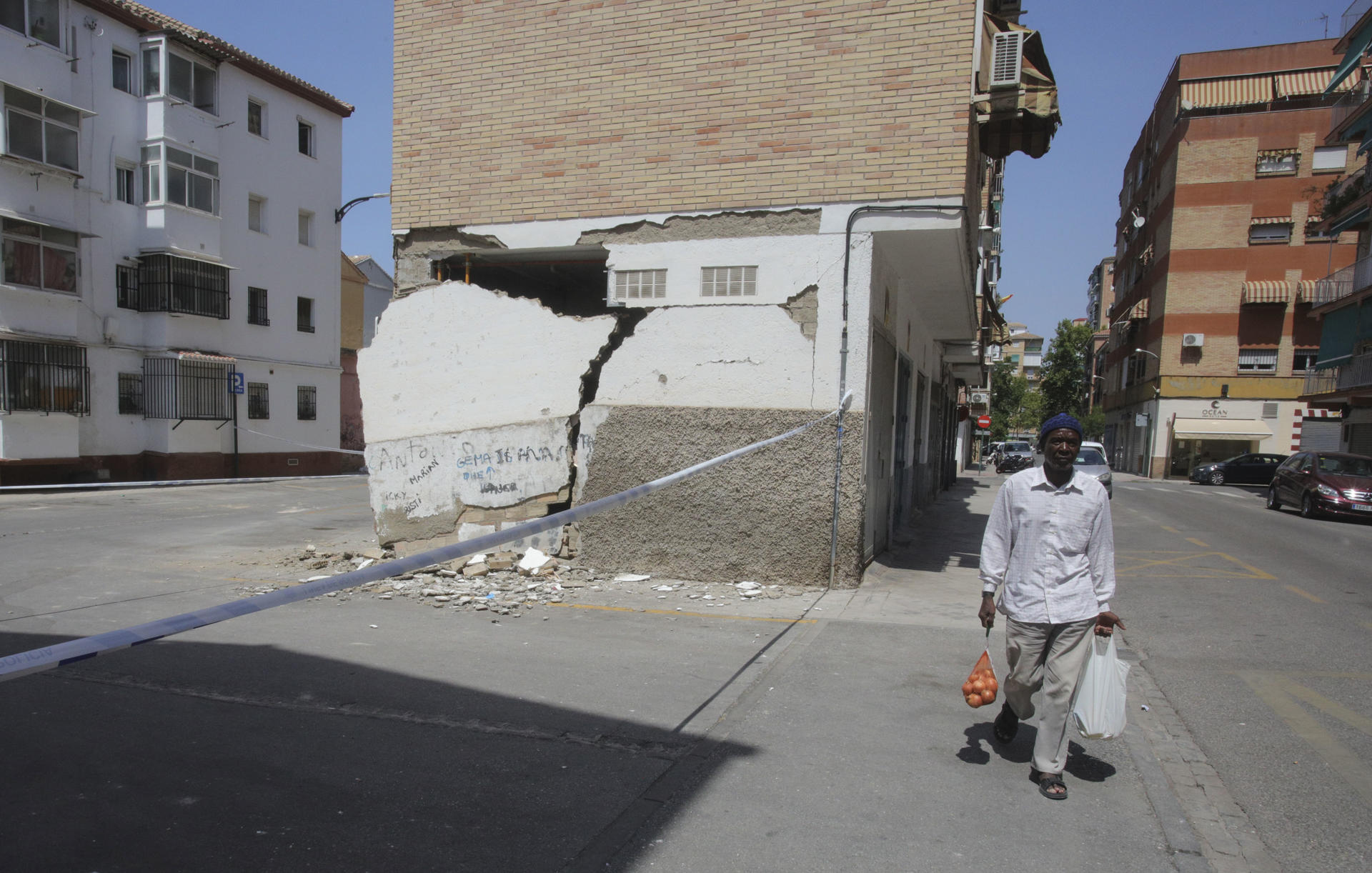 GRANADA 20/08/2026.- Un hombre pasa este jueves junto a una vivienda con desperfectos causados por los terremotos de los días anteriores en Granada. EFE/Pepe Torres.