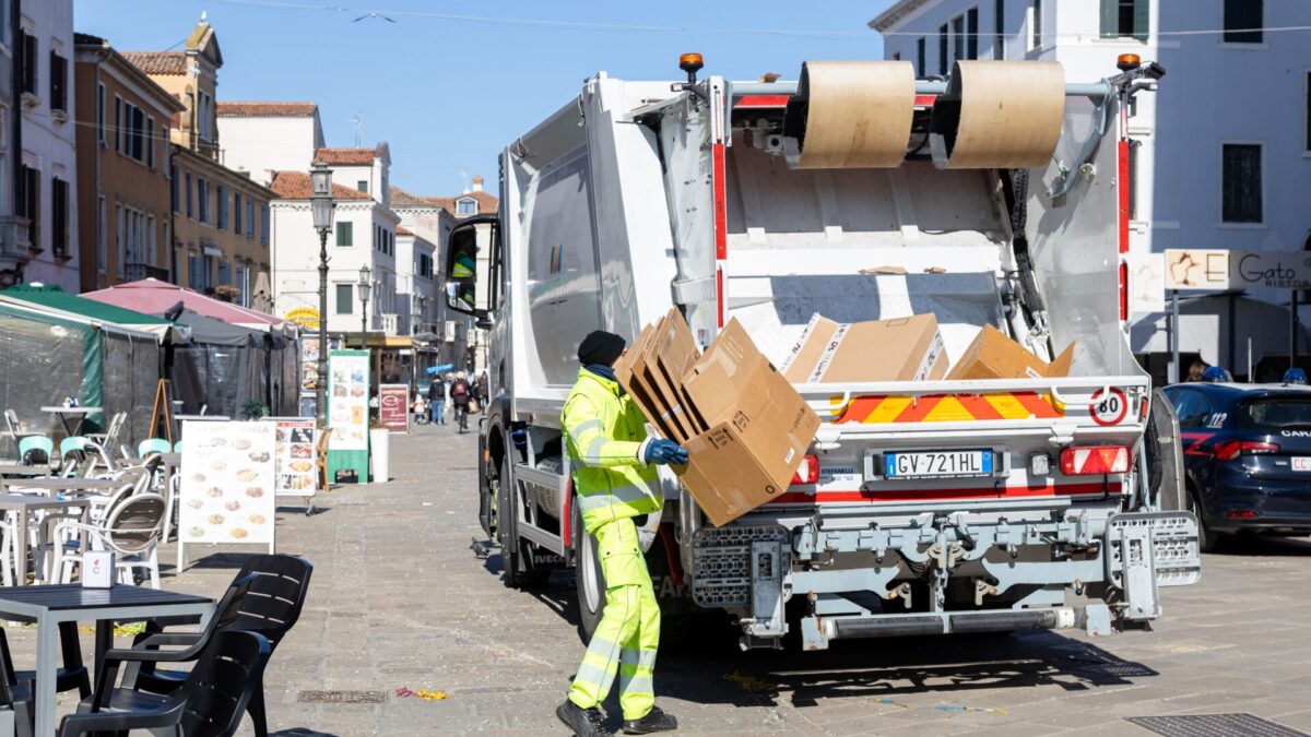 Chioggia, Italia - 3 de marzo de 2025: Un trabajador municipal recoge cajas de cartón para reciclaje con un camión de basura.