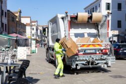 Chioggia, Italia - 3 de marzo de 2025: Un trabajador municipal recoge cajas de cartón para reciclaje con un camión de basura.