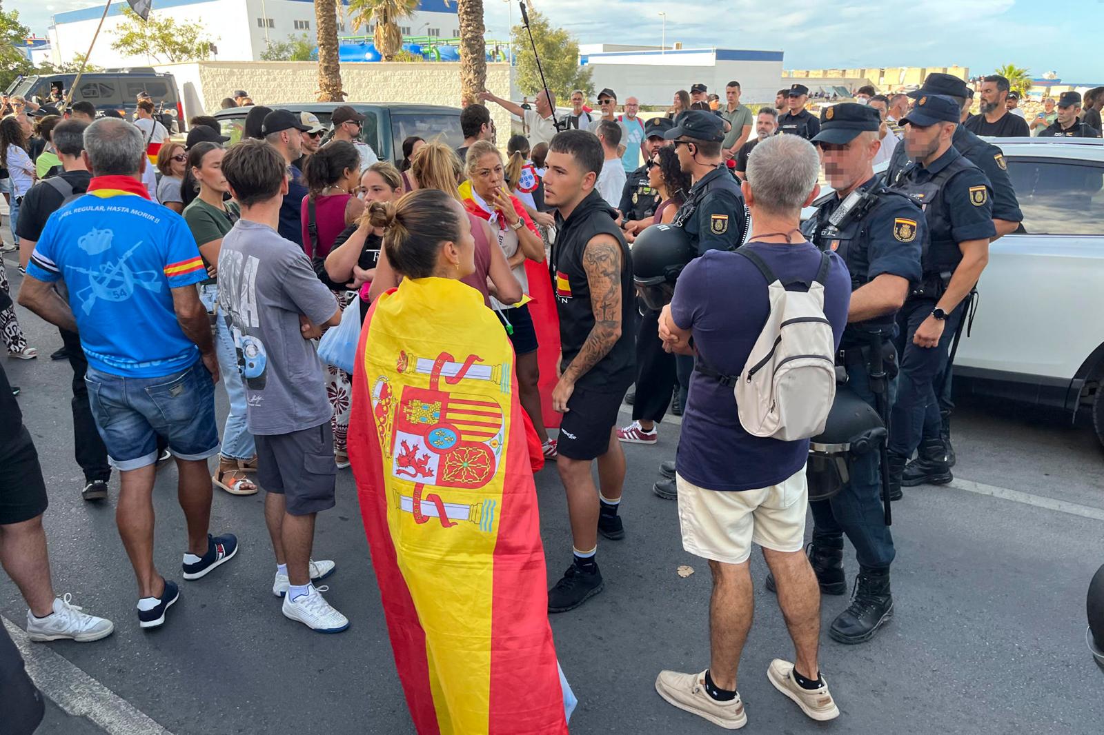 Ciudadanos impiden el acceso a miembros de Cruz Roja para entregar alimentos a los migrantes en la playa del Trampolín, este jueves en Ceuta. EFE/Reduan