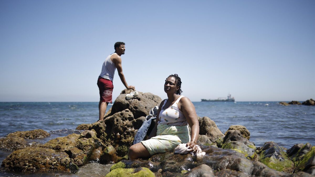 Un hombre y una mujer migrante en la playa, a 2 de agosto de 2026, en Ceuta (España). - Jesús Torres - Europa Press