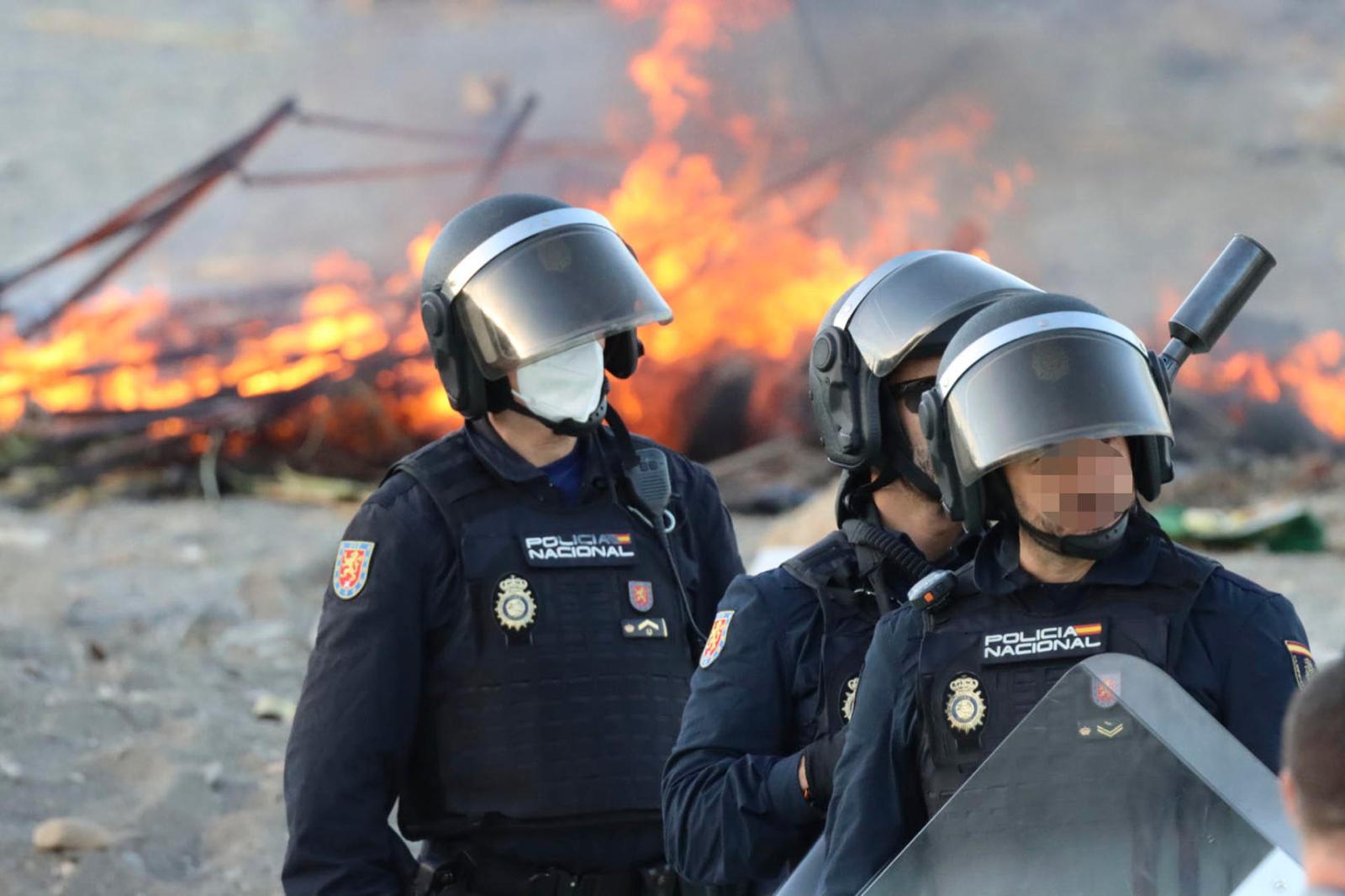 Presencia policial para evitar que continúen los incendios en las chozas constituidas por los migrantes en la playa del Trampolín este jueves en Ceuta. EFE/Reduan
