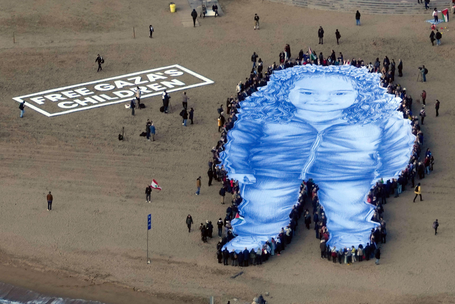 La organización Avaaz ha llevado a cabo una acción en la playa de Barcelona para recordar a Hind Rajab, una niña palestina que murió bajo fuego israelí junto a seis familiares hace dos años, mientras esperaba a los servicios de emergencia, que también fueron asesinados, una historia que inspira la película "La voz de Hind", nominada al Oscar. EFE/Enric Fontcuberta