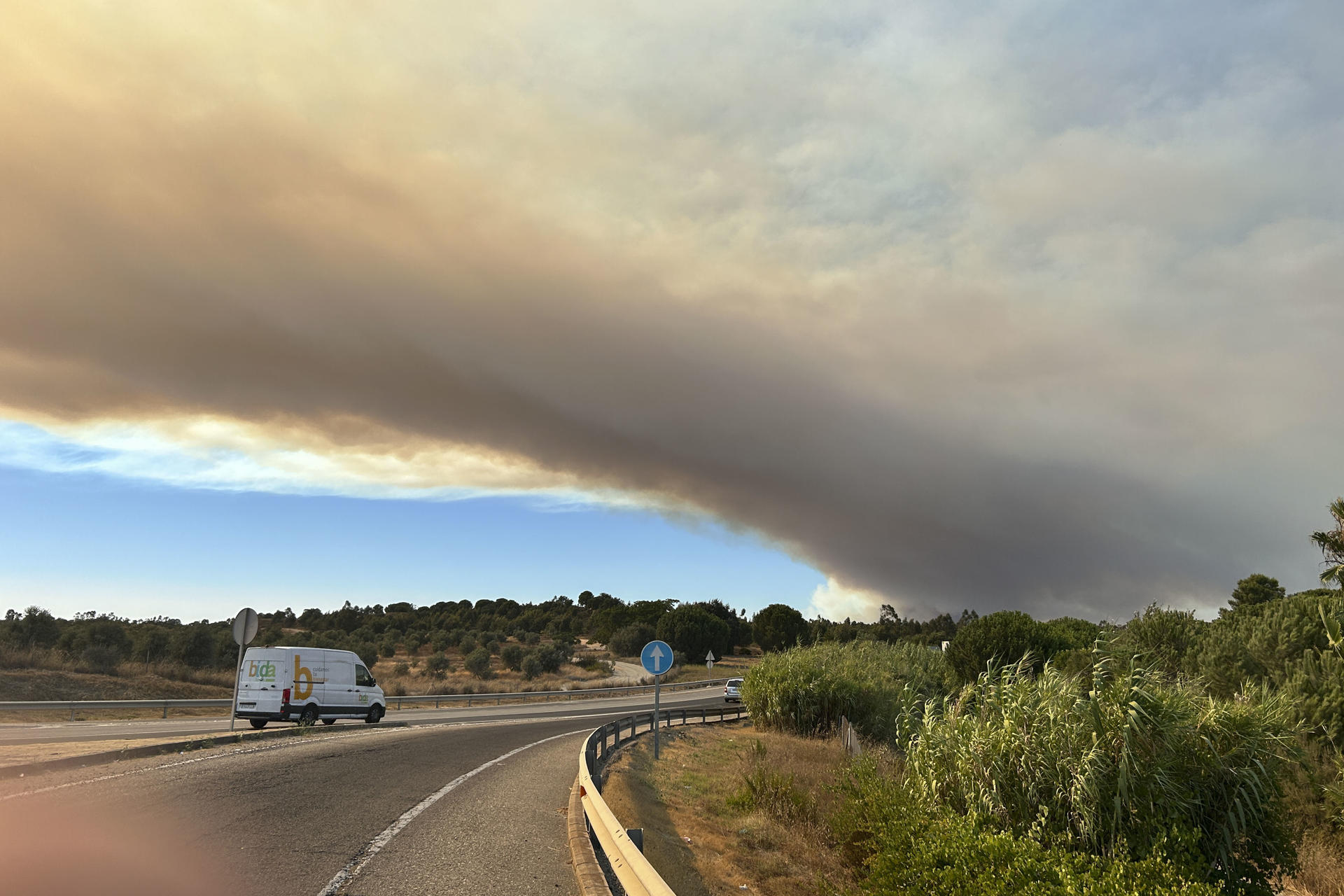 NIEBLA (HUELVA), 07/08/2026.- Incendio forestal que afecta a Niebla, en Huelva, que provoca una intensa columna de humo sobre las carreteras de la zona. El Plan Infoca mantiene movilizados 24 medios aéreos, además de un dispositivo terrestre de más de 120 efectivos, para las labores de extinción del fuego declarado en la tarde de ayer en Niebla, aún activo y que ha afectado ya a unas 380 hectáreas. EFE/Fermín Cabanillas