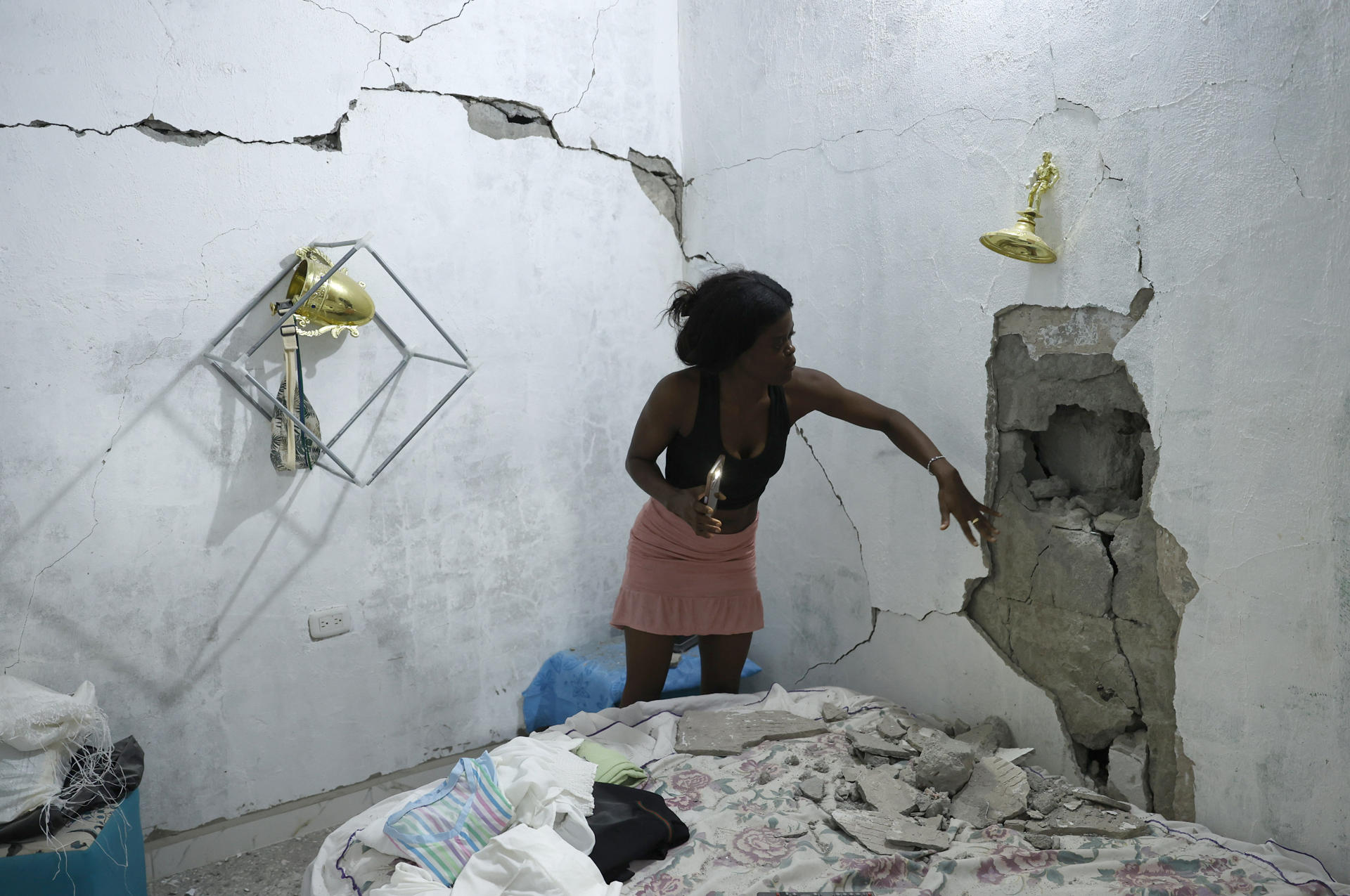 ACOMPAÑA CRÓNICA: COLOMBIA TERREMOTO AME8917. QUIBDÓ (COLOMBIA), 13/08/2026.- Una mujer muestra las grietas de su casa tras el terremoto del pasado lunes, este jueves, en Quibdó (Colombia). Mientras las autoridades intentan completar el censo con el dato total de damnificados por el terremoto de magnitud 7,4, que sacudió el oeste de Colombia, las familias afectadas tienen un diagnóstico propio: casas inhabitables, paredes a punto de colapsar y un futuro lleno de incertidumbre. EFE/Mauricio Dueñas Castañeda