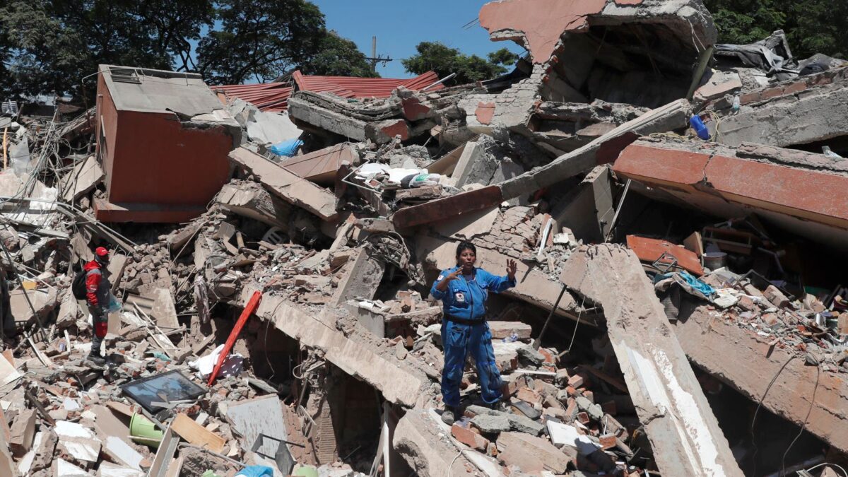 Personas trabajan en labores de rescate en una edificación colapsada por el terremoto en Cali.
