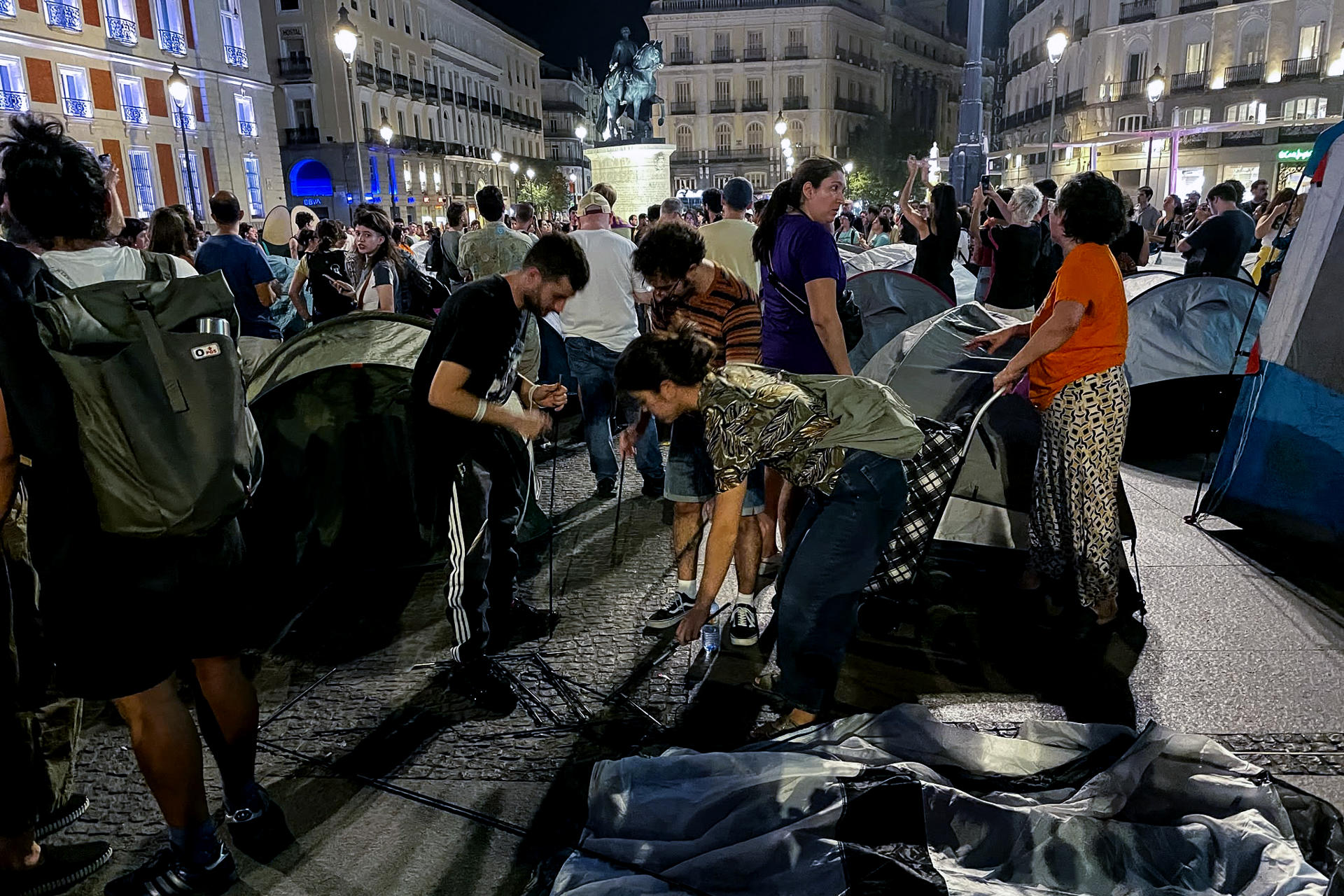 MADRID, 26/09/2026.-Centenares de personas han acampado la noche de este sábado en la Puerta del Sol de Madrid al término de la manifestación para protestar por el desahucio de Maricarmen, la anciana que tuvo que abandonar su vivienda de alquiler tras 70 años en la misma, y reclamar medidas efectivas para frenar la crisis de la vivienda. El Sindicato de Inquilinas ha hecho un llamamiento a acampar en Sol al finalizar la manifestación que ha tenido lugar esta tarde: "Acampada en Sol por el derecho a la vivienda. No aguantamos más. O cae el rentismo, o cae el gobierno. ¡Todo el mundo a Sol!", ha apuntado el Sindicato en un mensaje en su cuenta de X.- EFE/ Macarena Soto