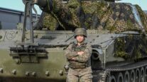 La cabo Nadia Arévalo, junto a uno de los vehículos militares del contingente español desplegado en Letonia