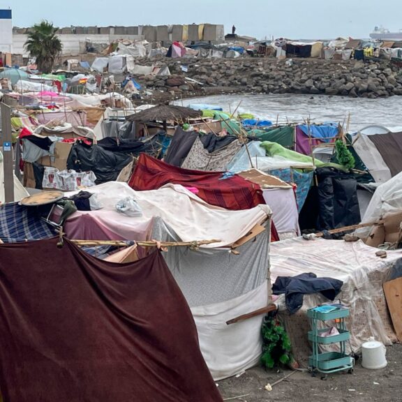 Varios miles de personas que entraron masivamente a la ciudad continúan acampados en las playas de Benítez y Trampolín a la espera de nuevos centros de acogida en Ceuta. EFE/Reduan