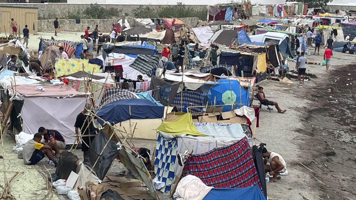 CEUTA, 12/09/2026.- Decenas de migrantes marroquíes han extendido este sábado su asentamiento ilegal en las costas de Ceuta a la playa de Benítez, situada al lado de la playa del Trampolín que se ha convertido en un lugar de cobijo de miles de personas que entraron los días 30 y 31 de julio. EFE/Reduan