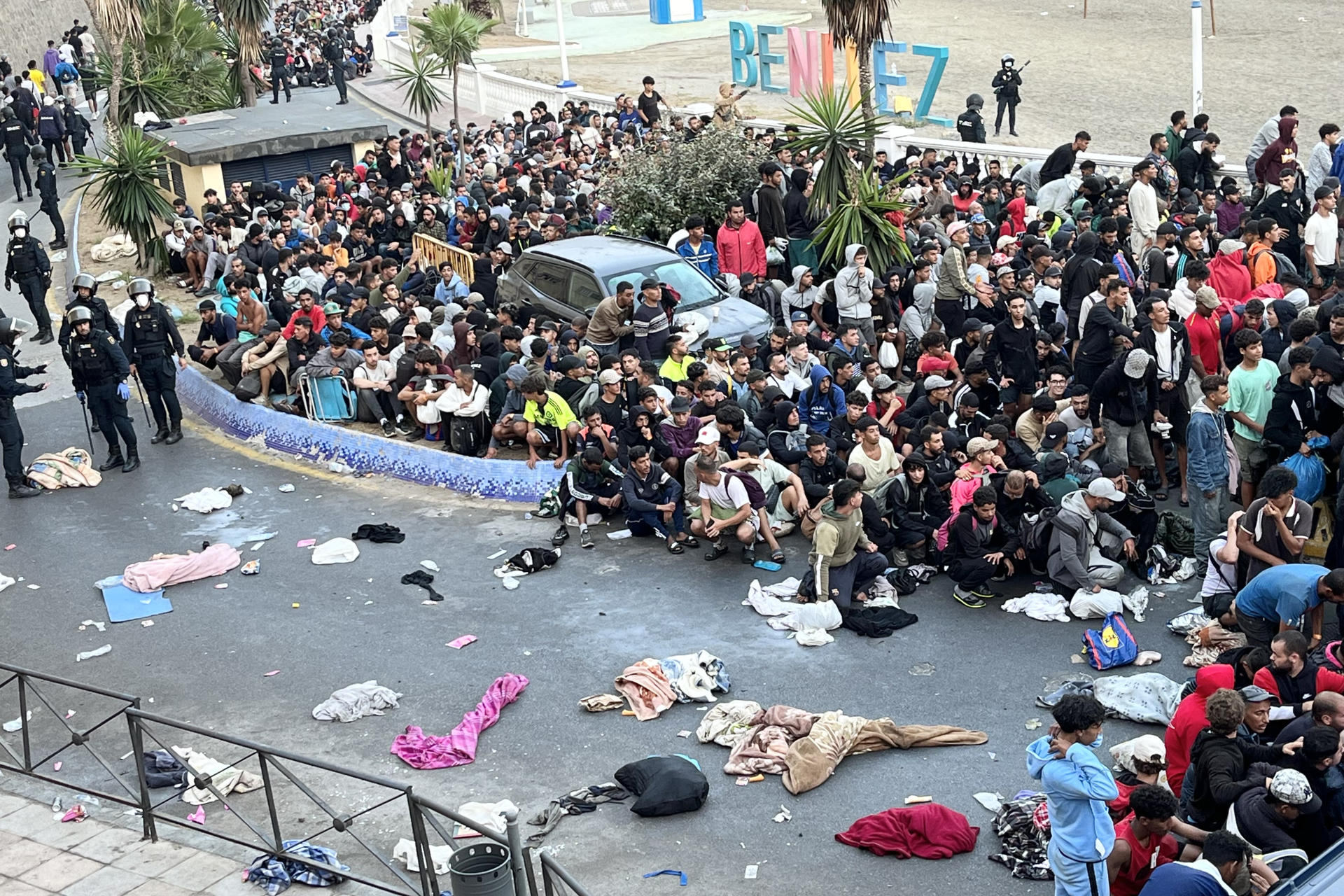 CEUTA, 18/09/2026.- Traslado de migrantes asentados en la playa de Benítez, este viernes. Las autoridades han iniciado a primera hora de este viernes el traslado de los migrantes asentados en las playas de Benítez y el Trampolín de Ceuta hasta el campamento temporal habilitado en el puerto de la ciudad, con capacidad para unas 1.700 personas. Un amplio dispositivo policial se ha desplegado en torno a las 7:15 de la mañana en ambos asentamientos, donde permanecen adultos y menores desde la entrada masiva registrada el pasado 30 de julio. EFE/Reduan