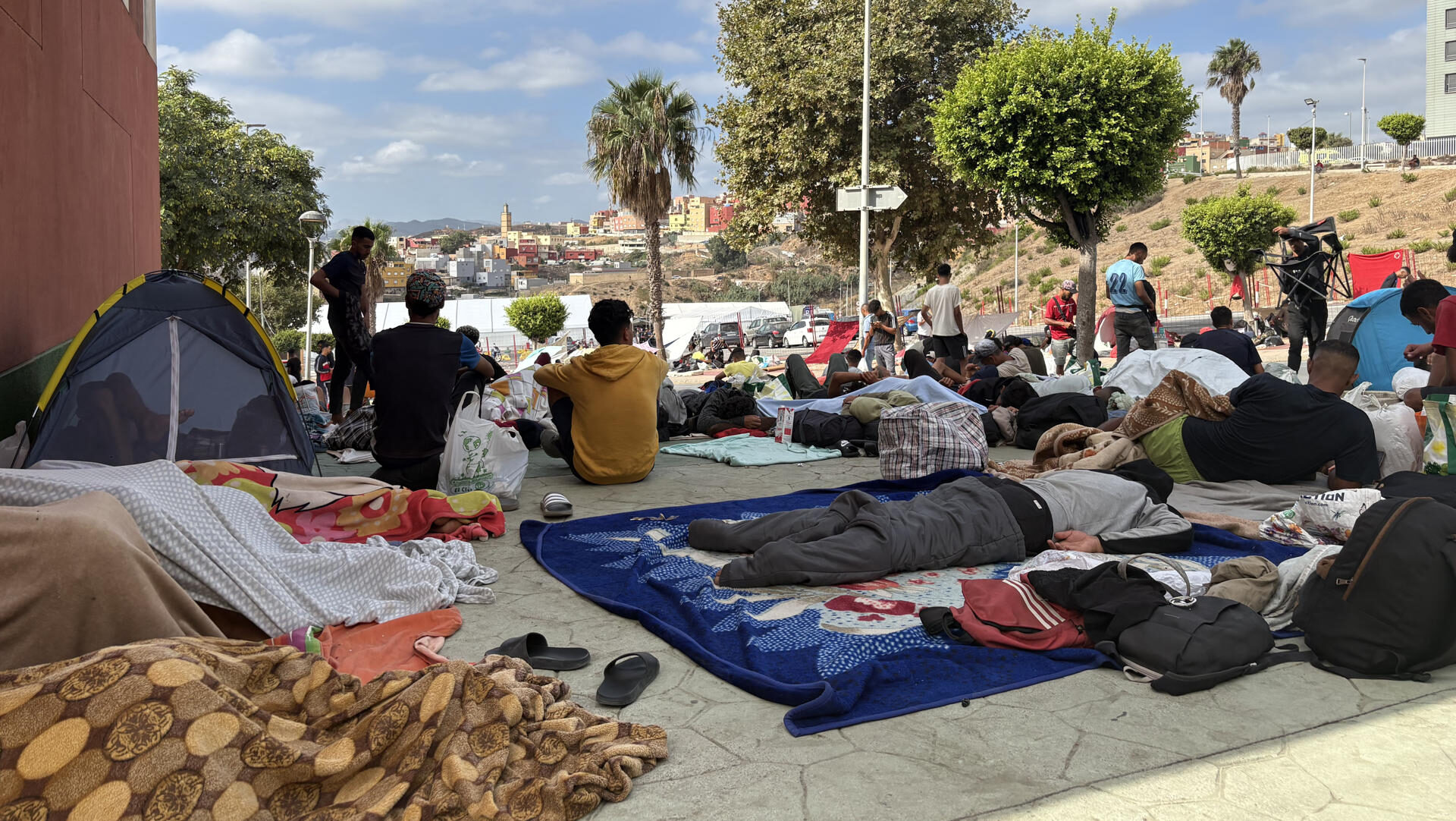 CEUTA, 10/09/2026.-Vista de exterior del asentamiento temporal de Loma Colmenar donde continúan los migrantes durmiendo en la calle esperando a ser aceptados en el interior. EFE/Laura Rincón