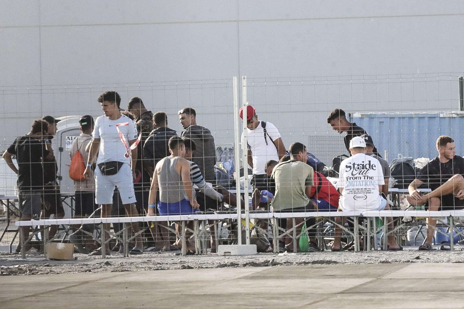 CEUTA, 19/08/2026.- Migrantes ya instalados este sábado en el centro temporal de migrantes en el muelle Poniente del puerto de Ceuta. EFE/Reduan